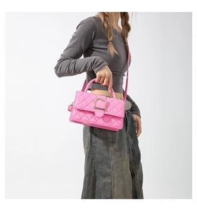 Détail du sac à main matelassé fuchsia avec boucle dorée élégante et poignée en cuir lisse
