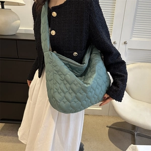 Detail of mint green tote bag featuring heart quilting and soft nylon material