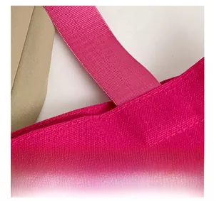 Détail de la bandoulière tissée et du tissu en toile rose sur un grand sac cabas