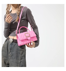 Gros plan d'un sac à main rose matelassé avec une élégante boucle en métal doré brillant