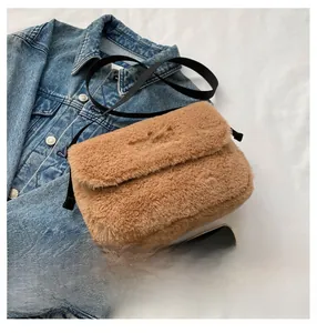 Détail du sac bandoulière en peluche marron avec broderie mini et fine lanière noire