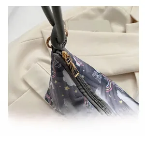 Detail of smooth gold zipper and knotted handle on quilted cartoon pattern bag