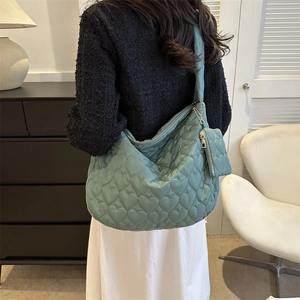 Detailed heart-quilted texture on mint green hobo bag with matching small coin pouch