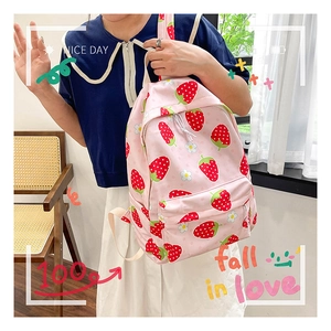 Close-up of pink canvas backpack with cute strawberry and daisy prints and front pocket