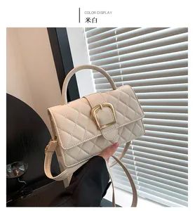 Détail du sac matelassé blanc cassé avec boucle dorée et poignée rigide