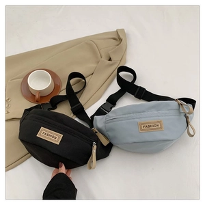 Dettaglio della borsa a tracolla in nylon con patch in pelle e cinturino regolabile