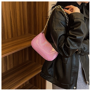 Pink iridescent moon bag with gold chain strap worn by a model in a leather jacket