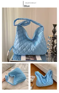 Gros plan du sac cabas matelassé bleu clair avec finition brillante et motif de losanges