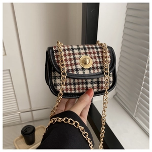 Detail of red and black plaid woolen mini bag with gold chain strap and metal buckle