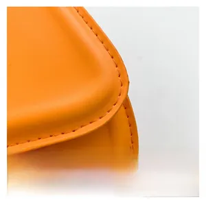 Close-up of orange leather texture and neat stitching details on the fashion saddle bag