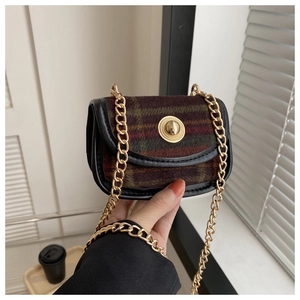 Close-up of vintage plaid tweed texture and golden round metal buckle on mini crossbody bag