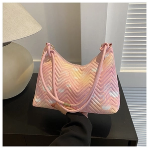 Close-up of pink quilted faux leather handbag with purple butterfly patterns and wave stitching