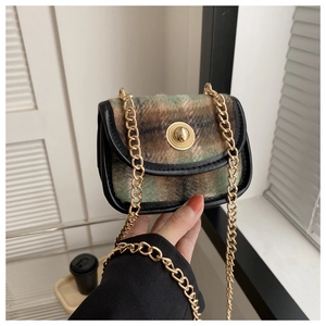 Close-up of vintage plaid woolen mini crossbody bag with gold chain and metal clasp