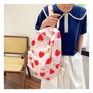 Lifestyle shot of pink strawberry canvas backpack for school girls with floral patterns