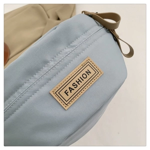 Dettaglio del borsello in nylon azzurro con patch logo Fashion kaki e tracolla in tessuto