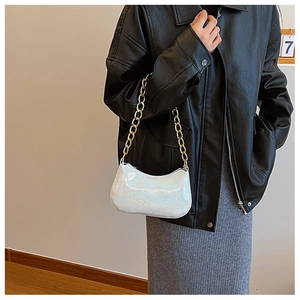 Chic pearlescent white crescent bag with gold chain strap shown on model's shoulder