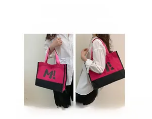 Détail d'un grand cabas en toile avec imprimé lettres montrant les styles main et épaule