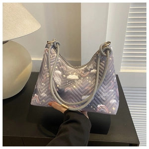 Close-up of quilted lavender shoulder bag with colorful rainbow and butterfly patterns