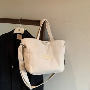 Off-white corduroy tote bag with embroidery, adjustable strap and shoulder handles
