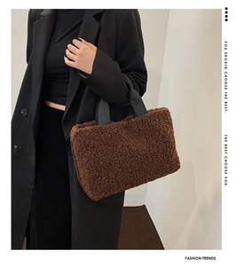 Detail of brown faux shearling tote bag with black woven handles for autumn and winter