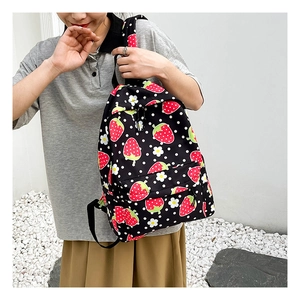 Detailed view of fresh strawberry and floral pattern on durable black canvas backpack fabric
