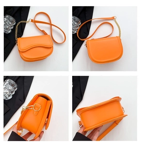 Detailed views of orange saddle bag with gold chain strap and smooth leather texture