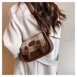 Detail der Vintage-Schultertasche mit Karomuster, Lederbesatz und Metallschnallen