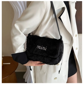 Détail du sac bandoulière en peluche noire avec broderie mini sur fausse fourrure