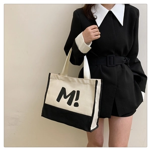 Détail du grand sac cabas en toile élégant avec impression de lettres noires et anses