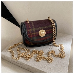 Detail of retro plaid tweed bag with gold relief buckle and chain shoulder strap