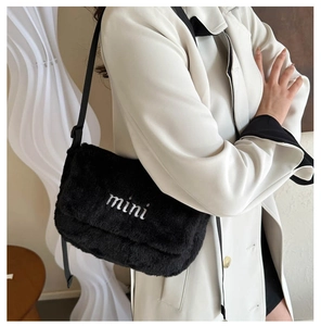 Détail du sac bandoulière en peluche noire avec broderie mini et sangle réglable
