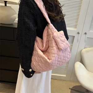Detail of pink quilted tote bag with heart pattern and matching mini coin purse accessory