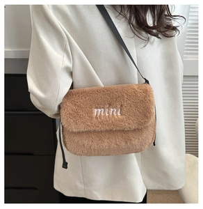 Vue détaillée du sac bandoulière en peluche marron avec broderie mini sur tissu doux