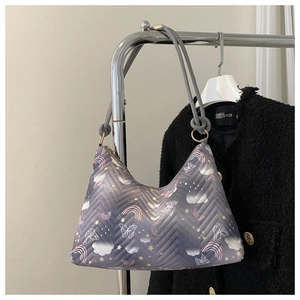 Detail view of grey quilted shoulder bag featuring colorful cartoon pattern and gold hardware