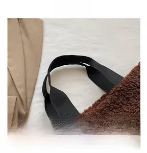 Detail view of brown sherpa bucket bag with durable black canvas handles and plush texture