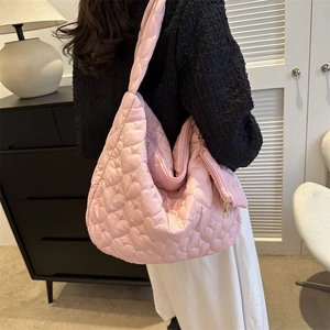 Detailed close-up of pink heart-quilted puffer tote bag with wide shoulder strap