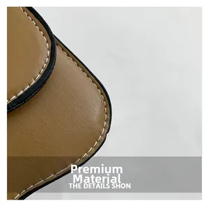 Détail de sac en cuir marron avec coutures contrastées blanches et finitions noires