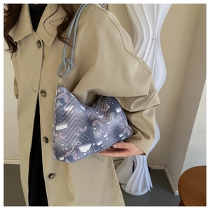 Quilted baguette bag with rainbow and butterfly prints worn over the shoulder