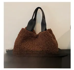 Detail of brown fluffy fleece tote bag with wide black fabric handles for autumn