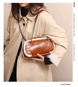 Detail view of brown leather bag with white plush trim and elegant metal chain strap