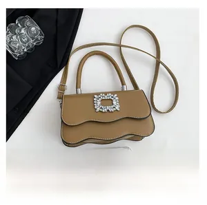 Détails du sac en cuir caramel avec rabat à bords ondulés et boucle en cristal