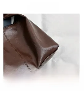 Close-up of deep brown lychee grain faux leather texture and neat stitching details