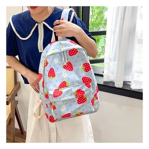 Close-up of strawberry pattern backpack with durable dual zippers and light blue fabric
