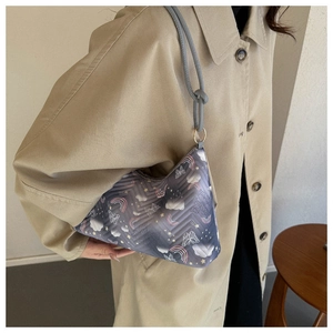 Detail of grey crescent shoulder bag with colorful cartoon patterns and V-shaped quilting