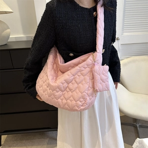 Pink heart quilted tote bag with matching pouch shown in a modern home setting