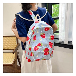 Detail of strawberry pattern schoolbag featuring front zipper pocket and floral prints