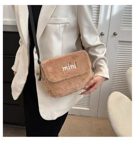 Sac bandoulière en fausse fourrure marron avec broderie mini porté par un mannequin