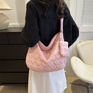 Close-up of pink heart-quilted shoulder bag with a small matching coin purse attachment