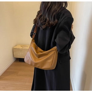 Sac hobo marron en cuir grainé porté par un mannequin pour montrer la taille et la forme souple