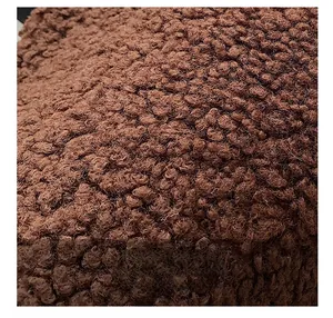 Close-up of premium brown faux shearling fabric texture with thick curly fibers